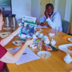 Ambassador Karin Boven examines the 2023 UPDS report and print Newsletter, showing amazement at the brilliant work done by UPDS. This moment occurred during a gathering to welcome back the One Young World ambassadors from the summit held in Belfast, United Kingdom.