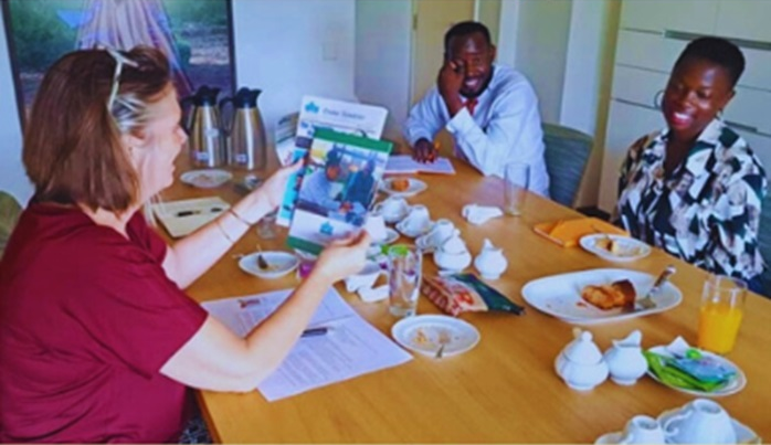 Ambassador Karin Boven examines the 2023 UPDS report and print Newsletter, showing amazement at the brilliant work done by UPDS. This moment occurred during a gathering to welcome back the One Young World ambassadors from the summit held in Belfast, United Kingdom.